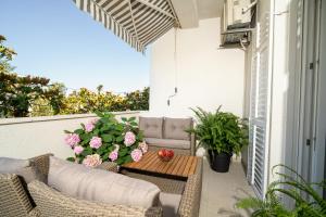 a patio with a couch and a table and flowers at Apartments Doris in Zadar