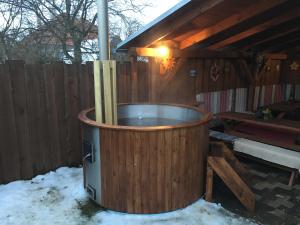 a hot tub in the snow next to a wooden building at Apartmány Crystal Jasná in Pavčina Lehota