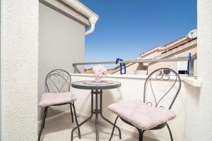 a small table and two chairs on a balcony at Apartments Doris in Zadar