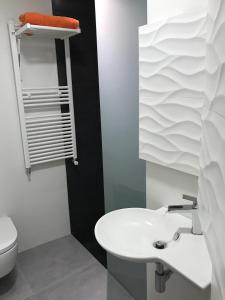 a bathroom with a white sink and a toilet at Smart-Tech Plaza Apartment in Salamanca