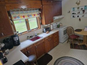a kitchen with wooden cabinets and a sink and a window at Yellow Barn House in Danbury