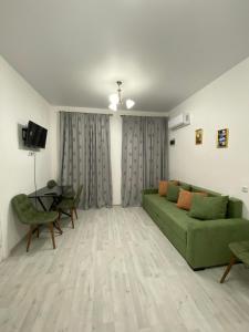a living room with a green couch and a table at Green Home on Mtatsminda in Tbilisi City
