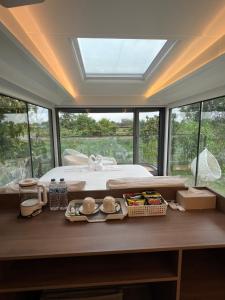 a bedroom with a bed and a large window at Nx Space พลูวิลล่า in Nakhon Nayok