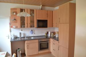 a kitchen with wooden cabinets and a sink at Zum Zingelforst in Neudorf