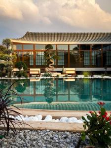 a building with a swimming pool in front of it at THE JAPANESE HOUSE by BRIDGE RETREATS in Ras al Khaimah