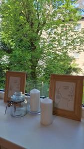 a table with two candles and two pictures on it at Boarder City Center Apartment, Võidu tn 5, Apt 16, 4th Floor, Narva in Narva +2 photos