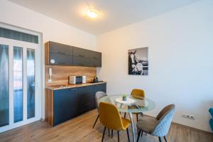 a kitchen and dining room with a table and chairs at AH-Corso Wellness Panorama Apartman in Siófok