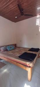 a bed in a room with a ceiling at Serina Guest House Malvan in Malvan