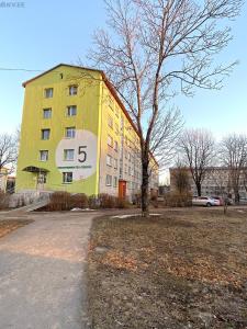 a yellow building with a clock on the side of it at Boarder City Center Apartment, Võidu tn 5, Apt 16, 4th Floor, Narva in Narva