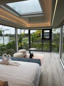 two beds in a room with large windows at Nx Space พลูวิลล่า in Nakhon Nayok