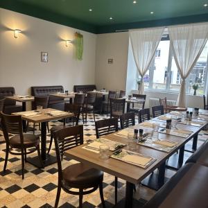 a dining room with tables and chairs and windows at La Canopée in La Gouesnière +11 photos