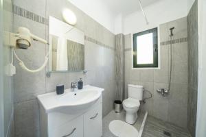 a bathroom with a sink and a toilet and a mirror at Villa Verde with Outdoor Jacuzzi in Divarata