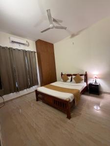 a bedroom with a bed and a ceiling fan at Villa Ecotiva Mahabalipuram in Chennai +58 photos