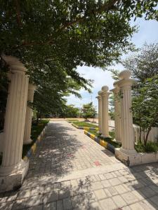 a cobblestone street with columns and trees on a sidewalk at Villa Ecotiva Mahabalipuram in Chennai