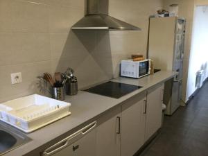 a kitchen with a stove top oven and a sink at Linar Do Rei in Linares