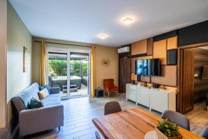 a living room with a couch and a table at AH-Corso Wellness Residence in Siófok