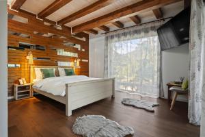 a bedroom with a bed and a wooden wall at Drago Chalet Sinaia, hot tub and sauna in Sinaia