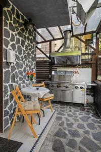 a kitchen with a table and a stone wall at Drago Chalet Sinaia, hot tub and sauna in Sinaia