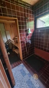a bathroom with a shower with brown tiles at Happy place in Kitee