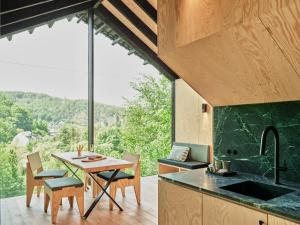 a kitchen with a table and chairs and a large window at Hutstuf La Roche-en-Ardenne in La-Roche-en-Ardenne