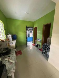 a living room with green walls and a room with at Familia homes in Lipa