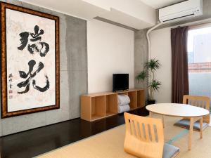a living room with a table and a tv at Eight One in Osaka