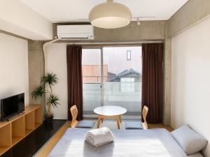 a bedroom with a bed and a table and a window at Eight One in Osaka +38 photos