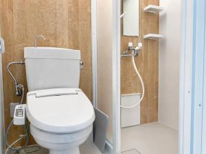 a bathroom with a white toilet and a shower at Eight One in Osaka