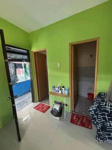 a room with green walls and a room with a table at Familia homes in Lipa