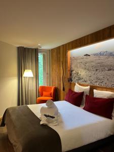 a hotel room with a bed and a chair at Hôtel LAPIAZ & Spa - FLAINE in Flaine