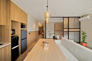 a kitchen and living room with a long wooden table at Oku Suites Bandung in Bandung