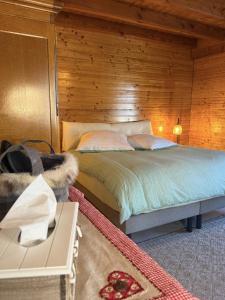 a bedroom with a bed and a wooden wall at Le Chalet Hubertus - Climatisé - 80 m2 in Rohrbach-lès-Bitche