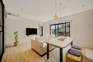 a living room with a table and a couch at Oku Suites Bandung in Bandung