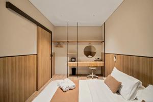 a bedroom with a bed with two towels on it at Oku Suites Bandung in Bandung
