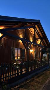 a wooden cabin with lights on the side of it at Le Chalet Hubertus - Climatisé - 80 m2 in Rohrbach-lès-Bitche