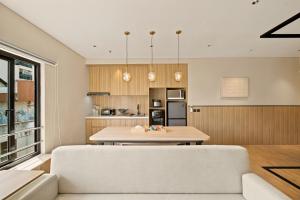 a kitchen and dining room with a table and a couch at Oku Suites Bandung in Bandung +24 photos