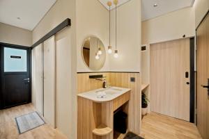 a bathroom with a sink and a mirror at Oku Suites Bandung in Bandung