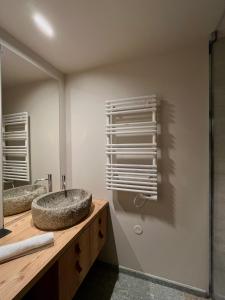 a bathroom with a stone sink and a mirror at Hôtel LAPIAZ & Spa - FLAINE in Flaine