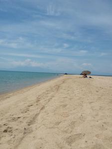 a person sitting under an umbrella on the beach at Villa Joanna 4 in Mesimérion