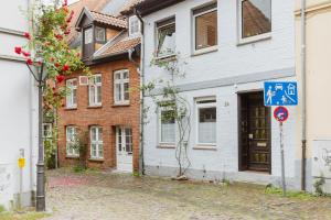 a street with a white building and a blue sign at HYGGE HOMES - Apartment 'gamleby' in Lüneburg