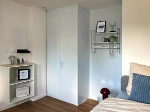 a bedroom with a white cabinet next to a bed at Stadtquartier Soest in Soest