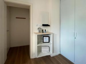 a room with a white shelf with a computer on it at Stadtquartier Soest in Soest