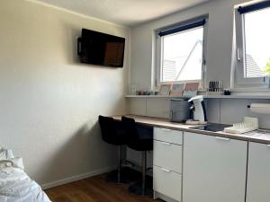 a room with a desk with a computer and two windows at Stadtquartier Soest in Soest +3 photos