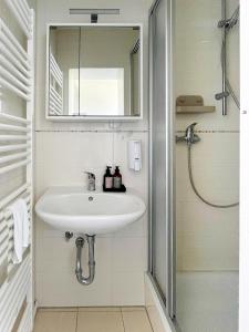 a bathroom with a sink and a mirror and a shower at Stadtquartier Soest in Soest