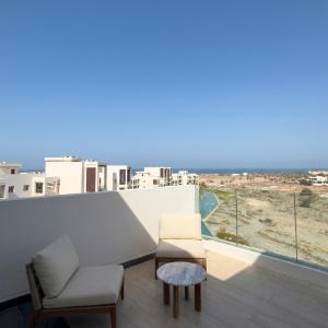 a balcony with two chairs and a table at Sifa Golf Lake in Muscat