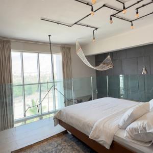 a bedroom with a large bed and a large window at Sifa Golf Lake in Muscat