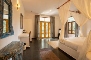 a bedroom with a bed with a canopy at Alpa Viram Retreat Goa in Mandrem +50 photos
