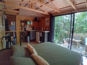 a living room with a bed and a large window at La cachette du G in Bellebrune