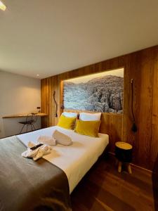 a bedroom with a large bed with yellow pillows at Hôtel LAPIAZ & Spa - FLAINE in Flaine +13 photos