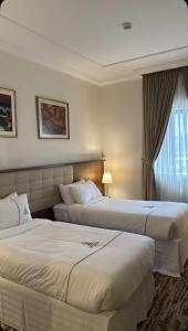 a hotel room with two beds and a window at فندق مزايا in Az Zāhir +16 photos